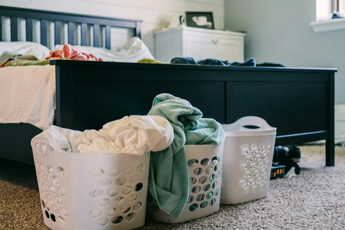 Laundry baskets full of clothes in a bedroom
